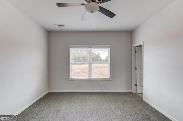 an empty room with a ceiling fan and a window
