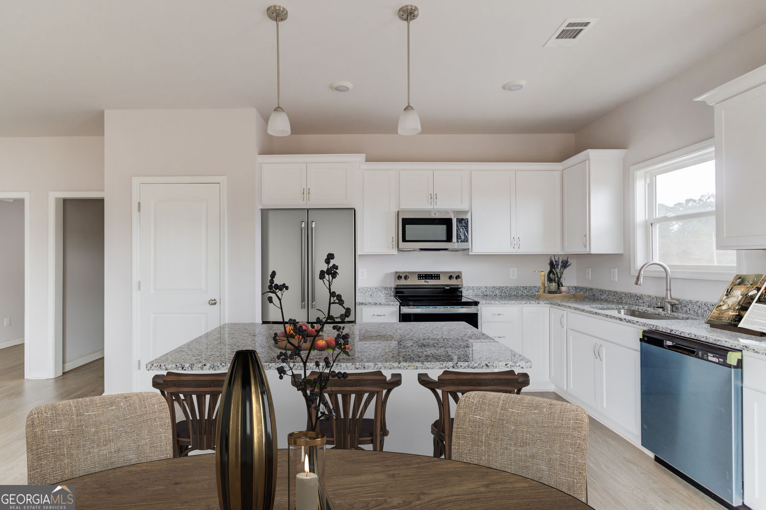 255 Cool Springs Road, Unit ROAD 7 Clarkesville, GA 30523 - Photo 41 of 42 a kitchen with stainless steel appliances granite countertop a stove a sink a microwave a refrigerator a dining table and chairs with wooden floor