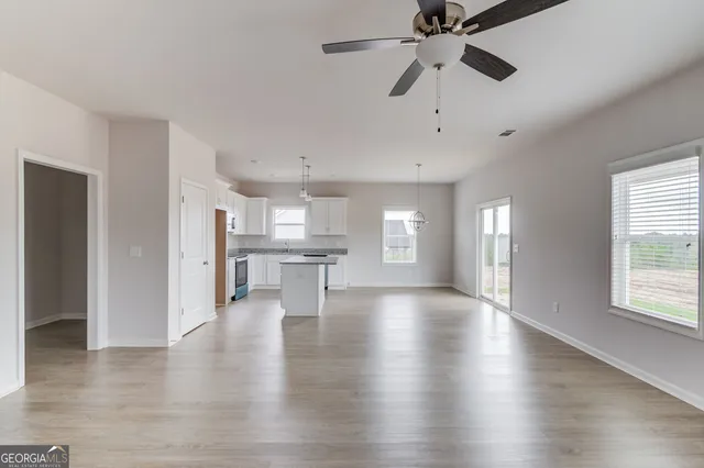 a view of empty room with wooden floor and window