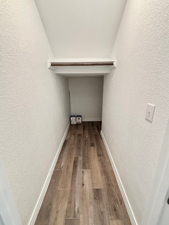 7606 Elk Grove Path Austin, TX 78653 - Photo 11 of 40 Corridor with light wood finished floors and a textured wall