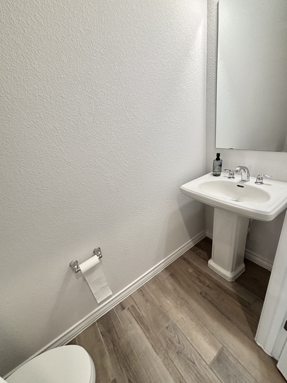 7606 Elk Grove Path Austin, TX 78754 - Photo 14 of 40 Half bathroom featuring light wood-type flooring and a textured wall