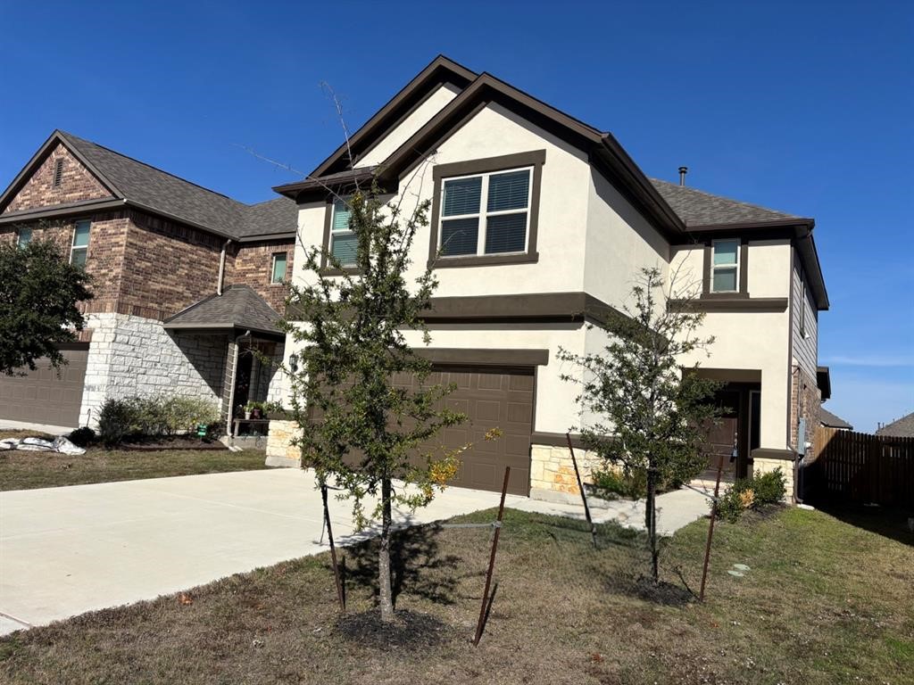 7606 Elk Grove Path Austin, TX 78754 - Photo 2 of 40 View of front of home with stone siding, stucco siding, an attached garage, and concrete driveway