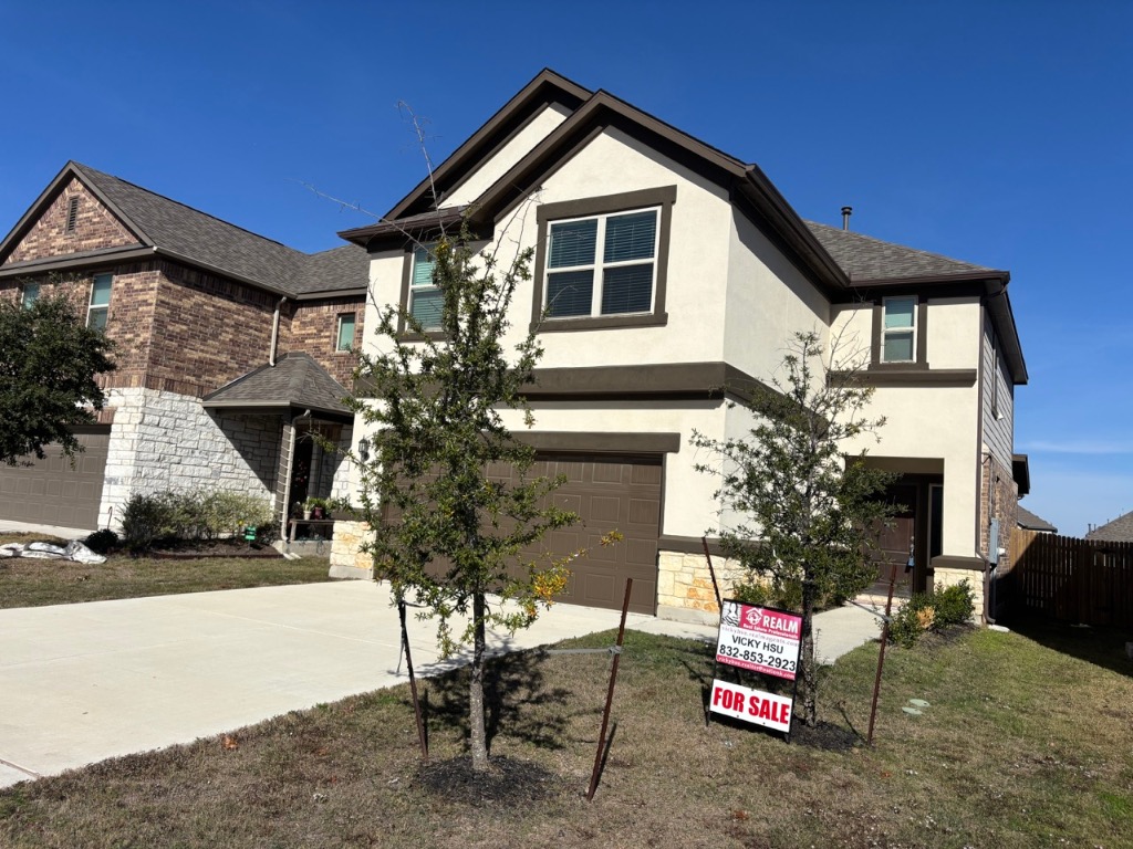 7606 Elk Grove Path Austin, TX 78653 - Photo 2 of 40 View of front of home featuring stucco siding, a garage, concrete driveway, and stone siding