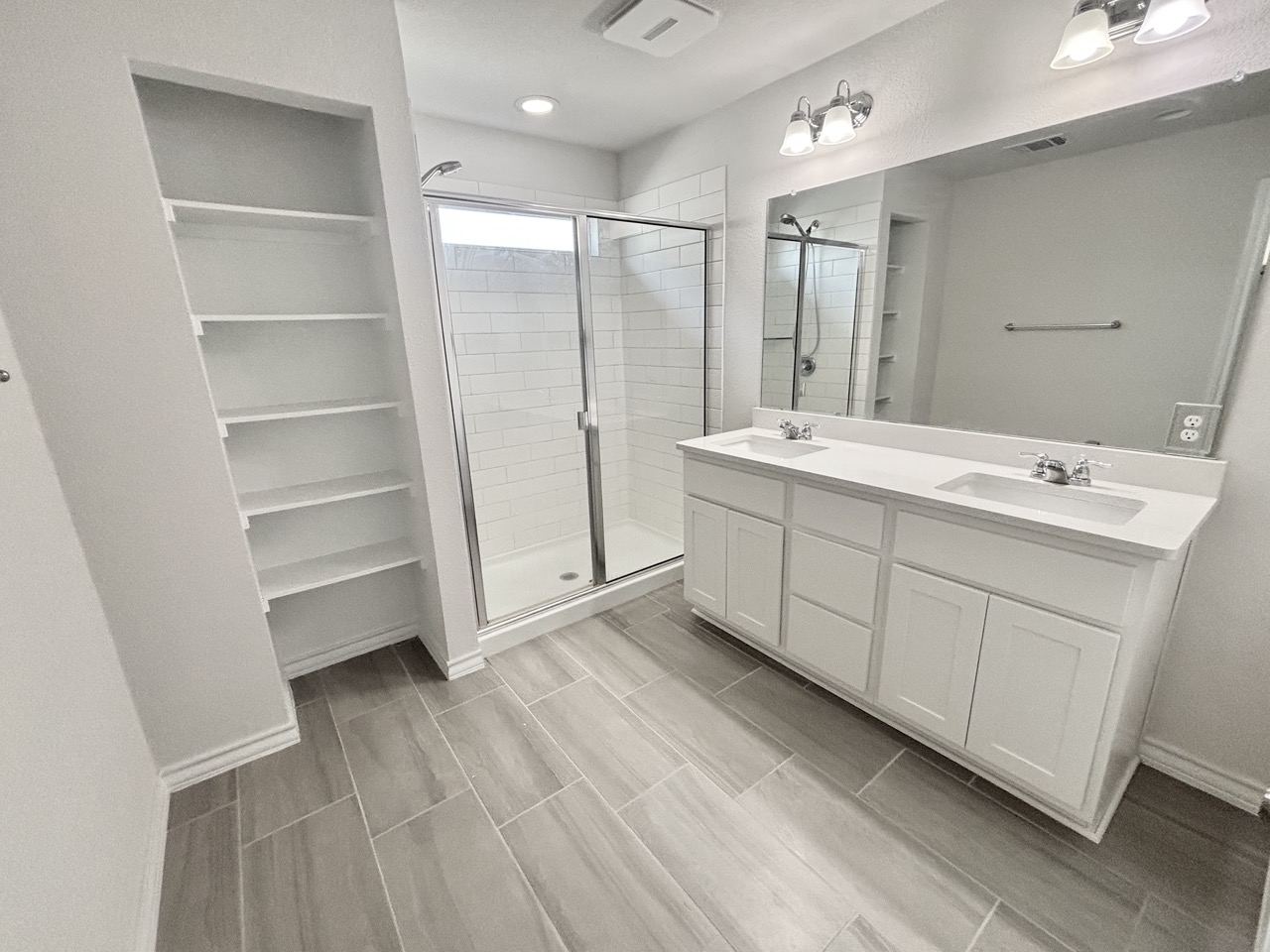 7606 Elk Grove Path Austin, TX 78754 - Photo 20 of 40 Full bathroom with double vanity, a shower stall, wood finish floors, and a spacious closet