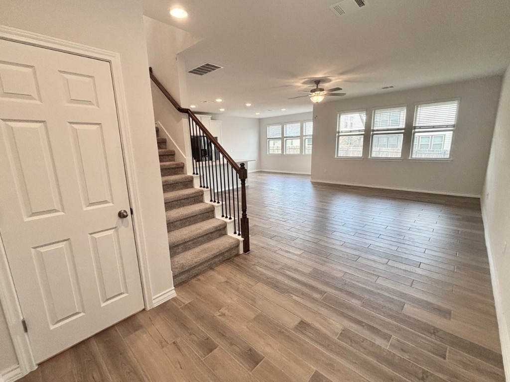 7606 Elk Grove Path Austin, TX 78653 - Photo 5 of 40 Unfurnished living room featuring light wood-type flooring, stairway, recessed lighting, and a ceiling fan