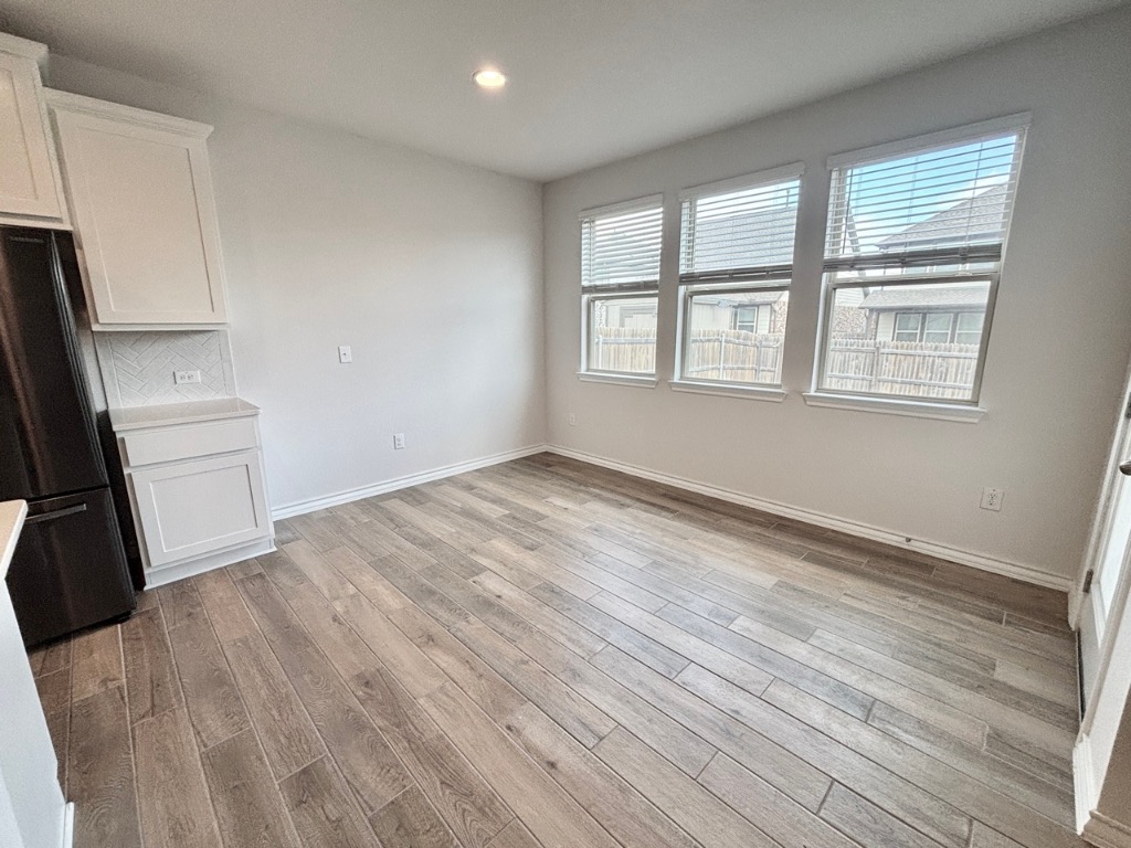 7606 Elk Grove Path Austin, TX 78653 - Photo 7 of 40 Unfurnished dining area with light wood-style flooring and recessed lighting