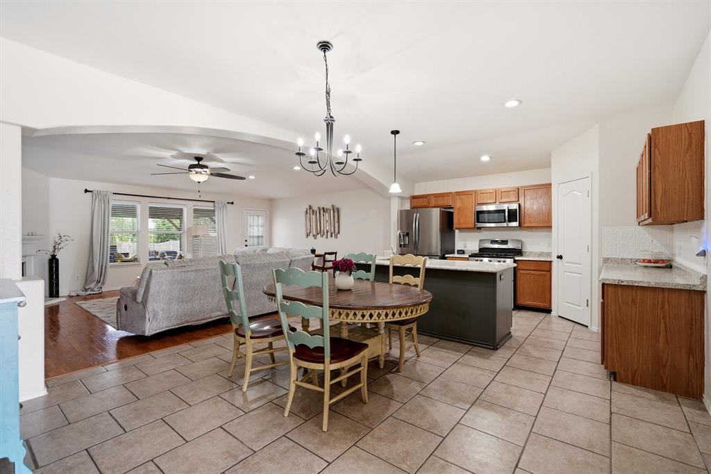1213 Hampton Drive Forney, TX 75126 - Photo 10 of 27 a dining hall with stainless steel appliances kitchen island granite countertop a table chairs and a refrigerator