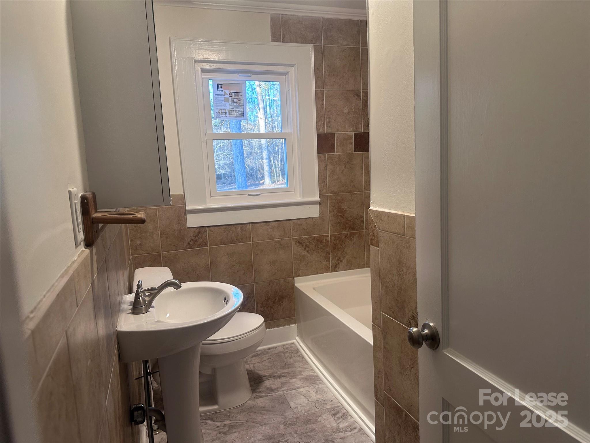 1255 Highway 24 Midland, NC 28107 - Photo 22 of 27 a bathroom with a sink a mirror a toilet and a bathtub