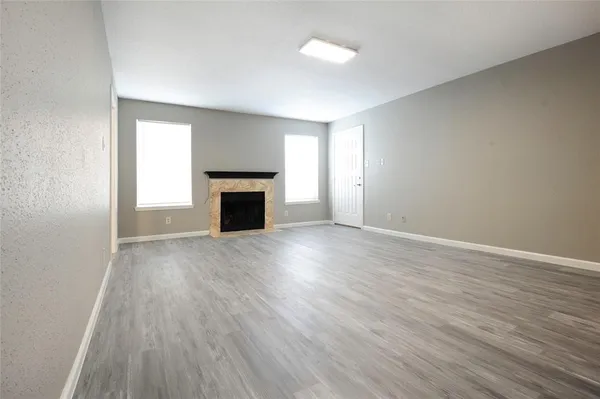 an empty room with wooden floor and a window