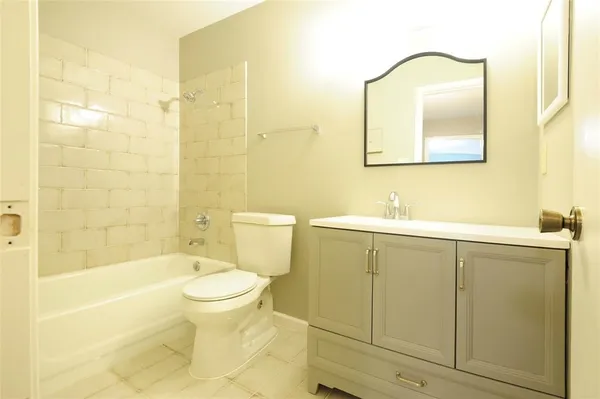 a bathroom with a toilet a sink a bath tub and mirror