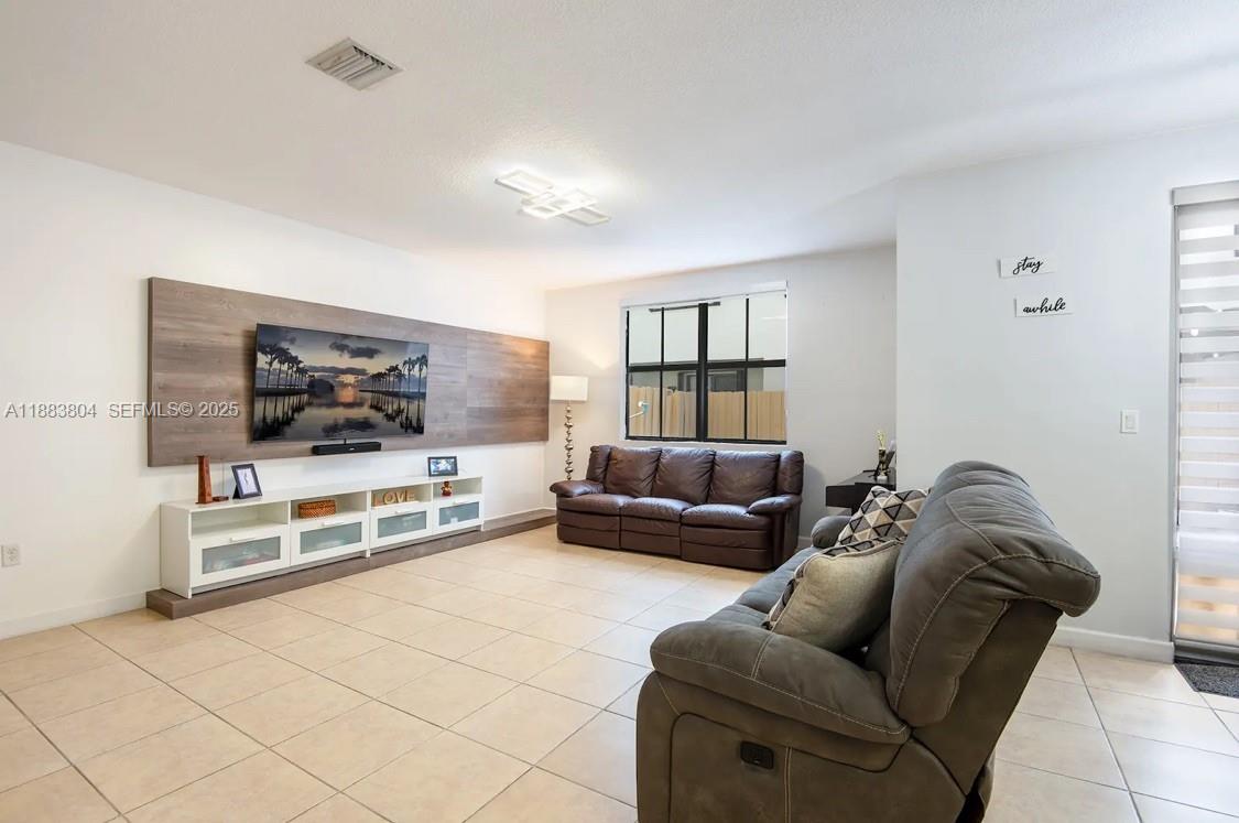 22509 Southwest 102nd Avenue Miami, FL 33190 - Photo 17 of 39 a living room with furniture and a flat screen tv