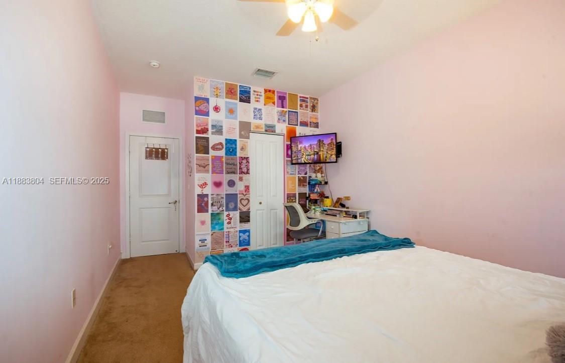 22509 Southwest 102nd Avenue Miami, FL 33190 - Photo 32 of 39 a bedroom with a bed and a bookshelf