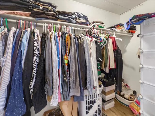 a view of walk in closet with clothes and shoes