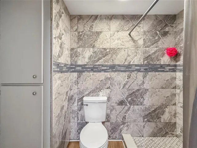 a bathroom with a toilet and a shower curtain