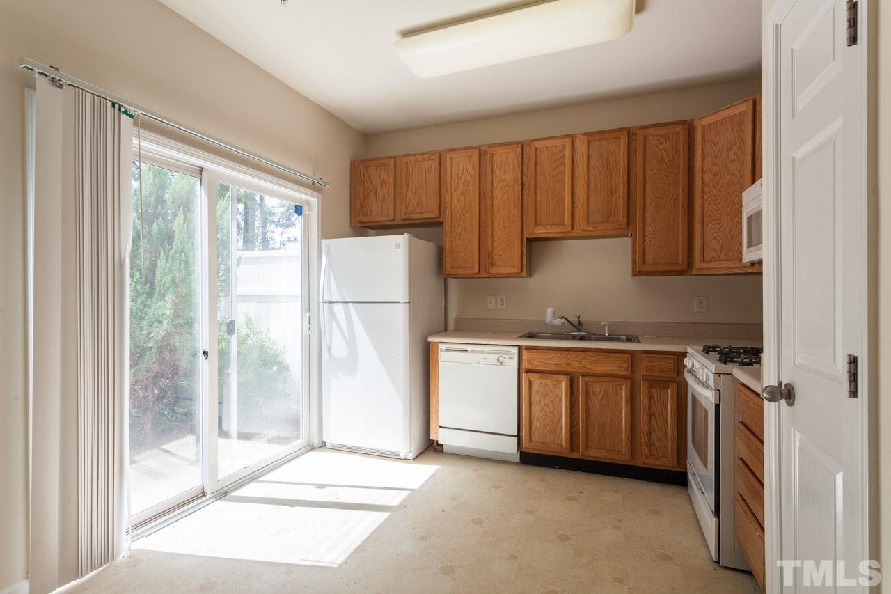8631 Neuse Club Lane, Unit 100 Raleigh, NC 27616 - Photo 11 of 25 a kitchen with a refrigerator a sink and cabinets