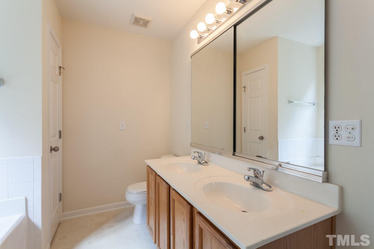 8631 Neuse Club Lane, Unit 100 Raleigh, NC 27616 - Photo 23 of 25 a bathroom with a sink toilet and mirror