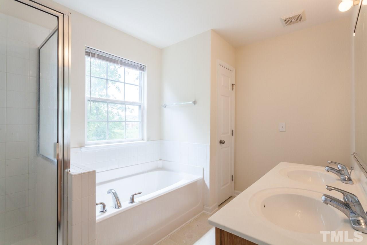 8631 Neuse Club Lane, Unit 100 Raleigh, NC 27616 - Photo 24 of 25 a bathroom with a bathtub and a sink
