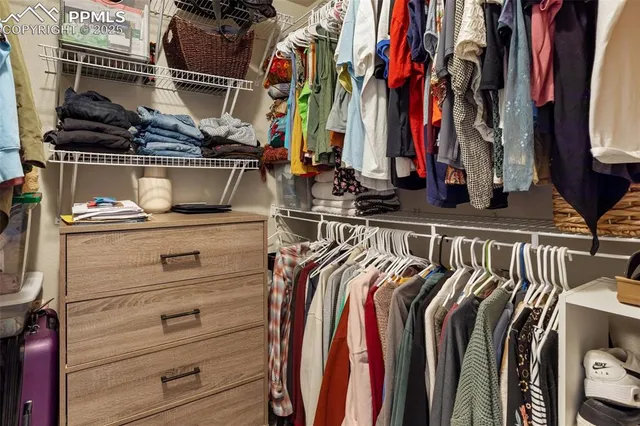 a view of walk in closet with clothes and shoes
