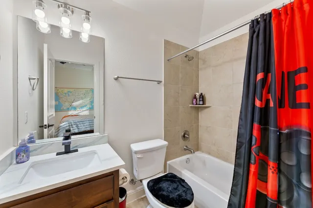 a bathroom with a sink a toilet and shower curtain