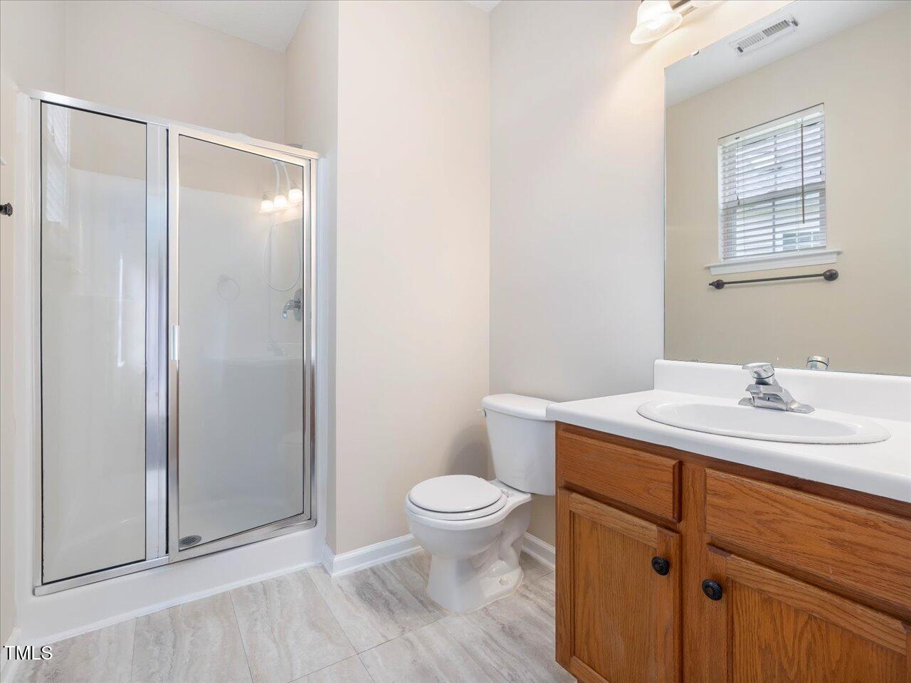 522 Auburn Square Drive Durham, NC 27713 - Photo 24 of 47 a bathroom with a sink a toilet a light fixture and a mirror
