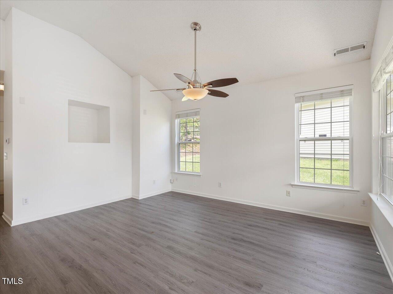 522 Auburn Square Drive Durham, NC 27713 - Photo 7 of 47 an empty room with wooden floor windows and ceiling fan