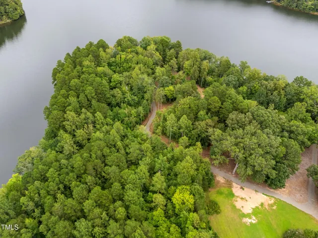 an aerial view of a house with a yard and lake view