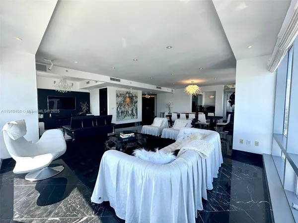 a living room with furniture a large window and a chandelier