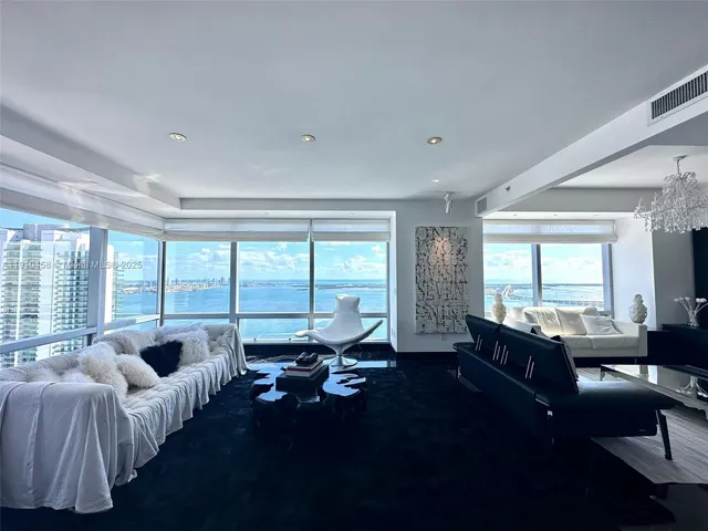 a living room with furniture and floor to ceiling window