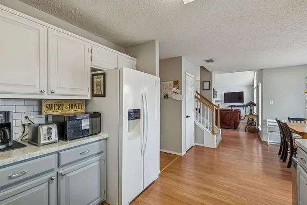a kitchen with stainless steel appliances white cabinets and wooden floor