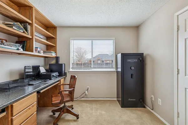 a view of a workspace with furniture and a window