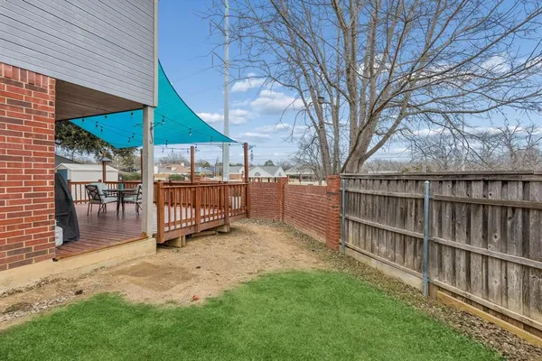 a view of a backyard with a sitting area and wooden fence