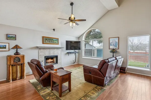 a living room with furniture a fireplace and a large window