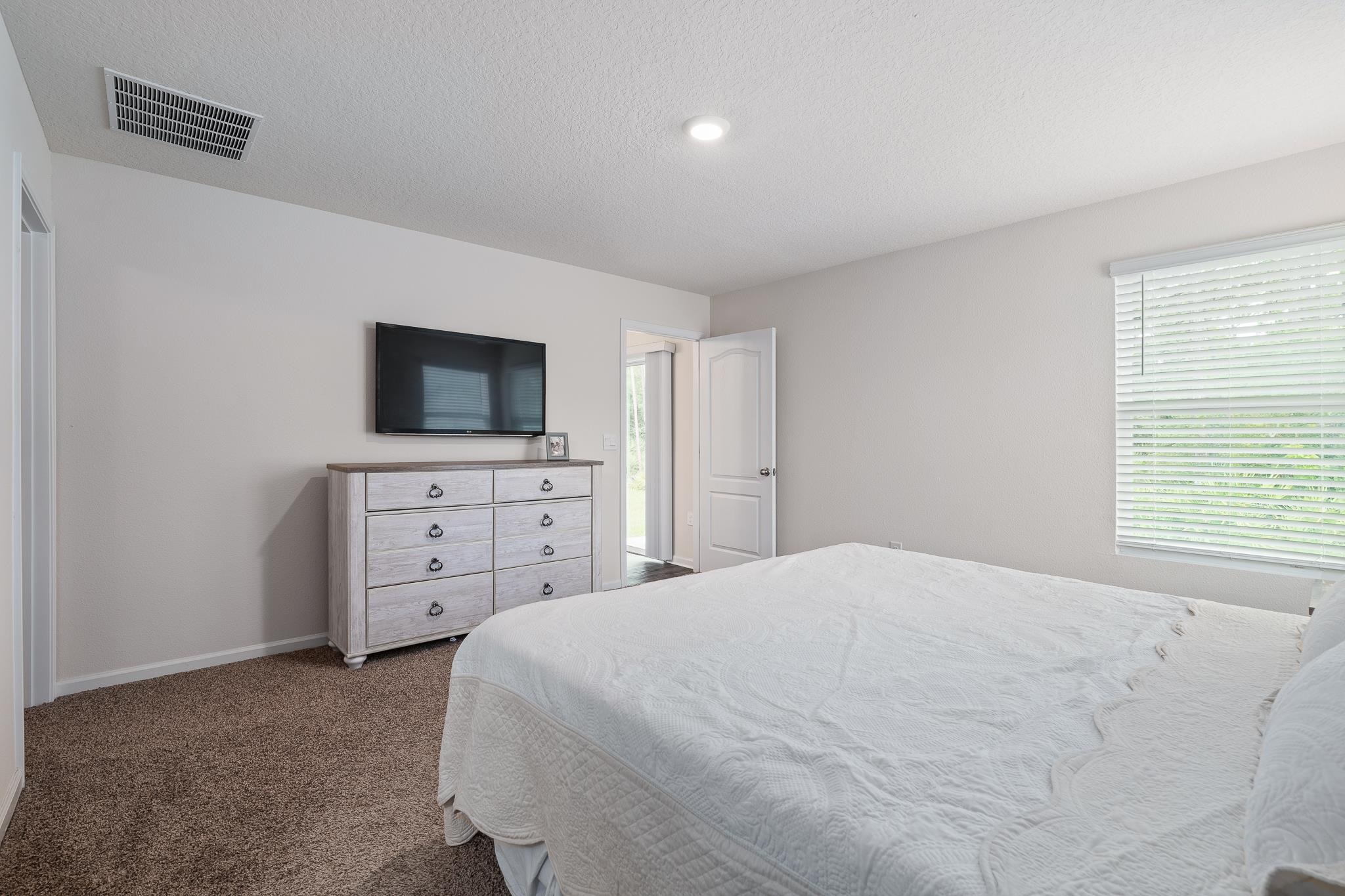 147 Logrono Court St. Augustine, FL 32084 - Photo 19 of 50 a bedroom with a bed and a flat screen tv