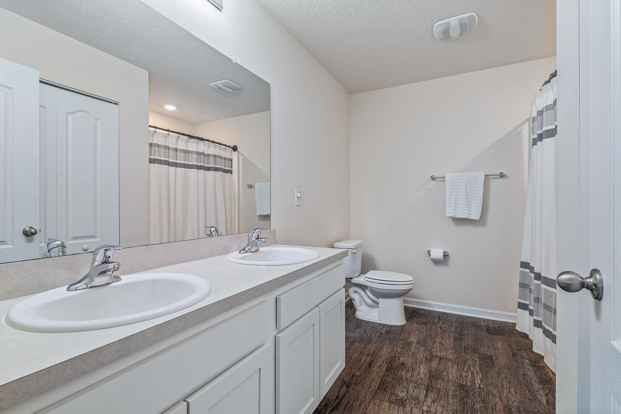 147 Logrono Court St. Augustine, FL 32084 - Photo 25 of 50 a bathroom with a double vanity sink toilet and mirror