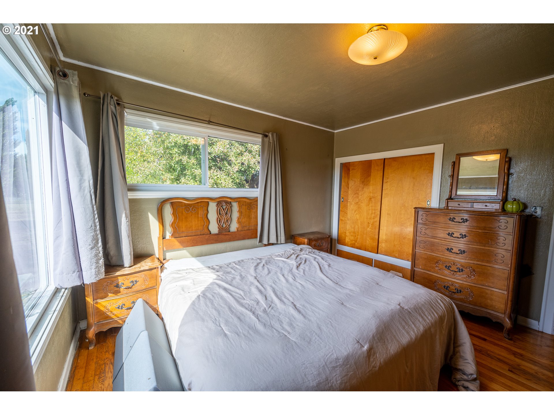 55561 Fishtrap Road Coquille, OR 97423 - Photo 28 of 31 a bedroom with a bed and wooden floor