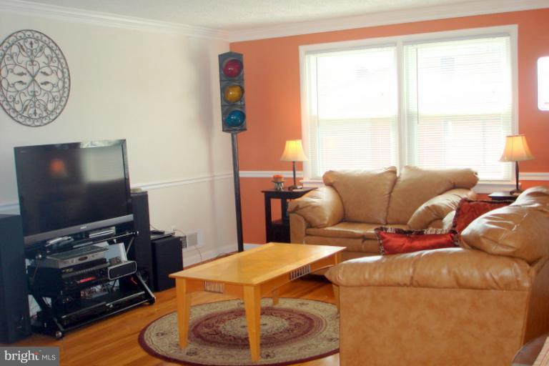 8803 Riggs Road Hyattsville, MD 20783 - Photo 2 of 24 a living room with furniture and a flat screen tv
