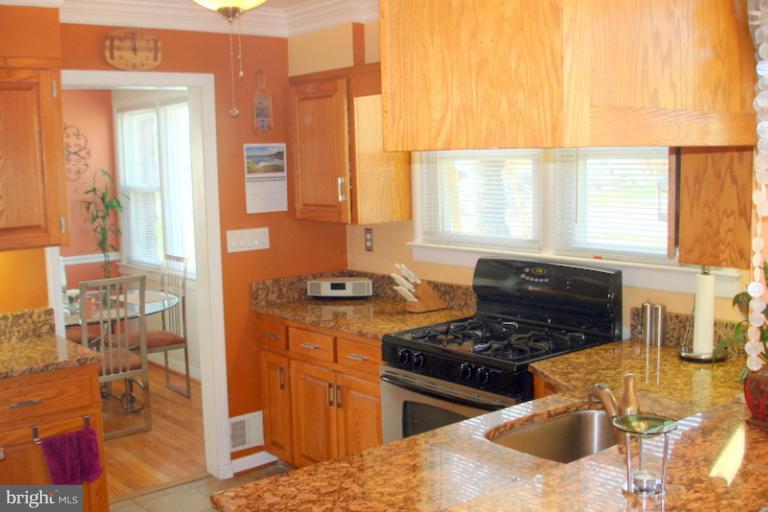 8803 Riggs Road Hyattsville, MD 20783 - Photo 19 of 24 a kitchen with stainless steel appliances granite countertop a stove a sink and a microwave