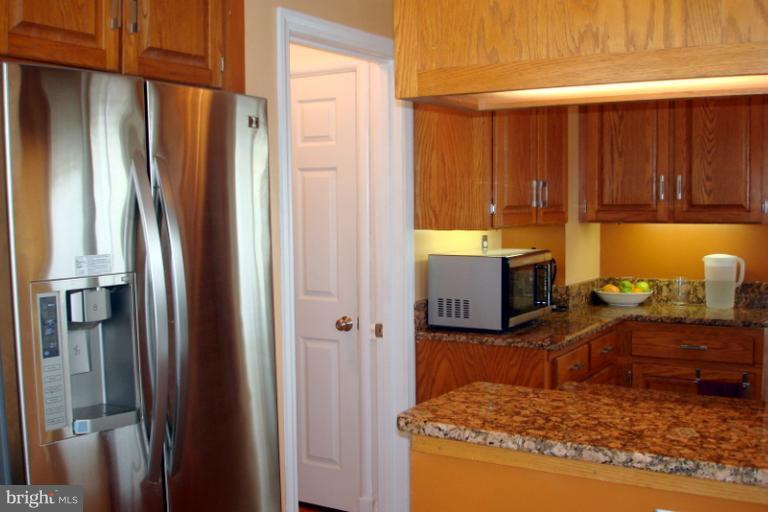 8803 Riggs Road Hyattsville, MD 20783 - Photo 24 of 24 a kitchen with stainless steel appliances granite countertop a refrigerator and a stove
