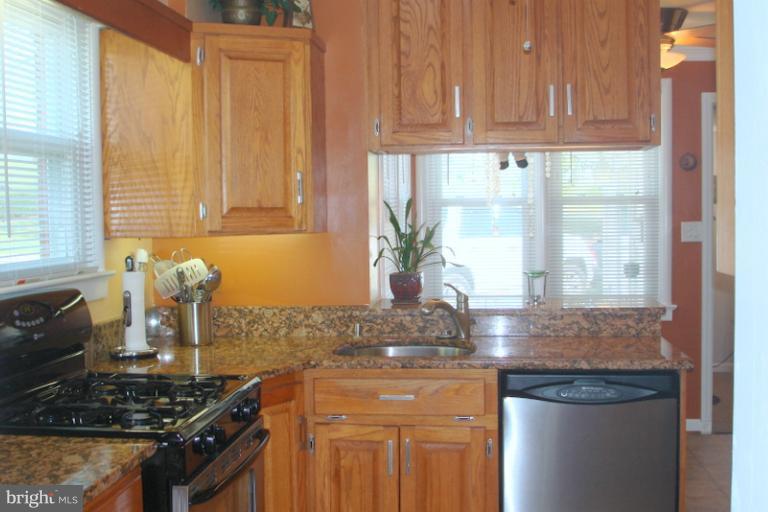8803 Riggs Road Hyattsville, MD 20783 - Photo 9 of 24 a kitchen with granite countertop a sink stainless steel appliances and a window
