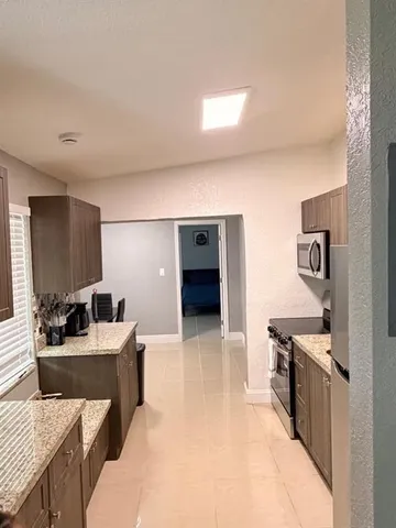 a living room with stainless steel appliances kitchen island granite countertop furniture and a kitchen view