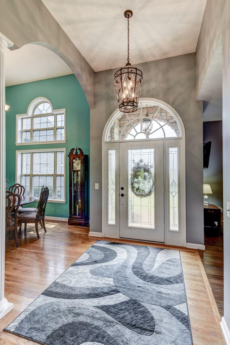 The Welcoming Foyer has a Door with a Palladium Window above, Hardwood Floors and welcomes guest to the open great room .