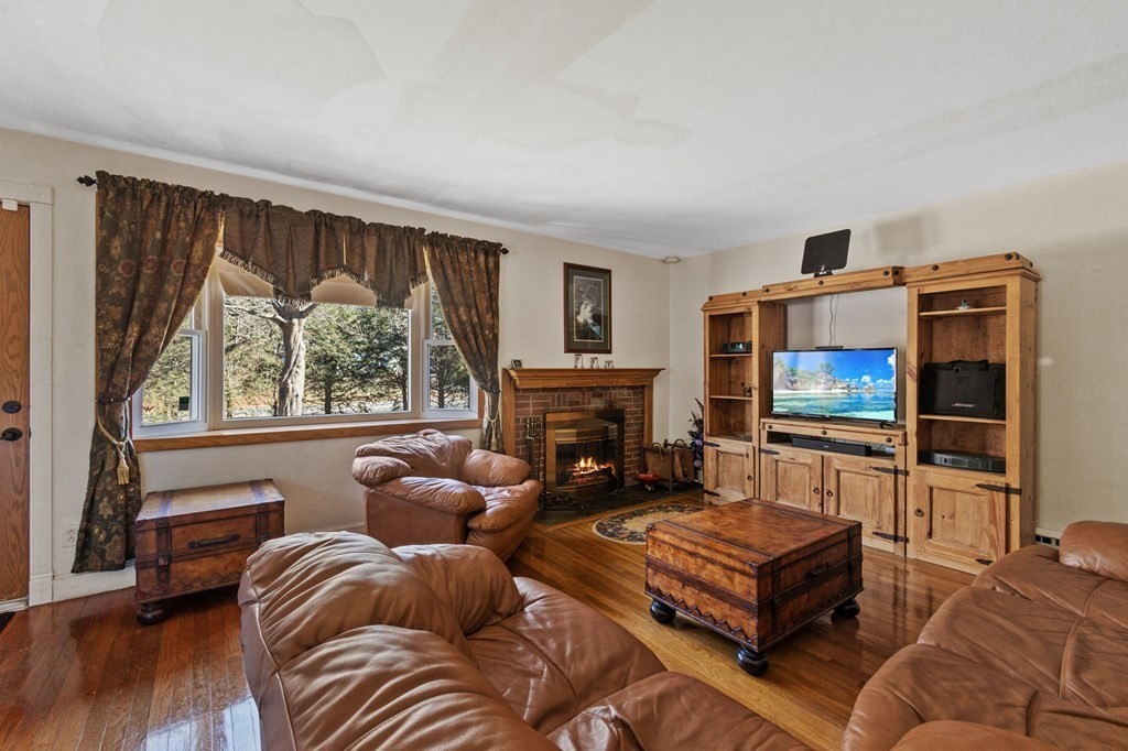1247 Bay Road Sharon, MA 02067 - Photo 11 of 41 a living room with furniture a fireplace and a flat screen tv