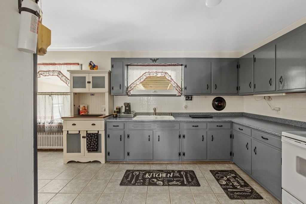1247 Bay Road Sharon, MA 02067 - Photo 12 of 41 a kitchen with granite countertop a stove a sink and a refrigerator