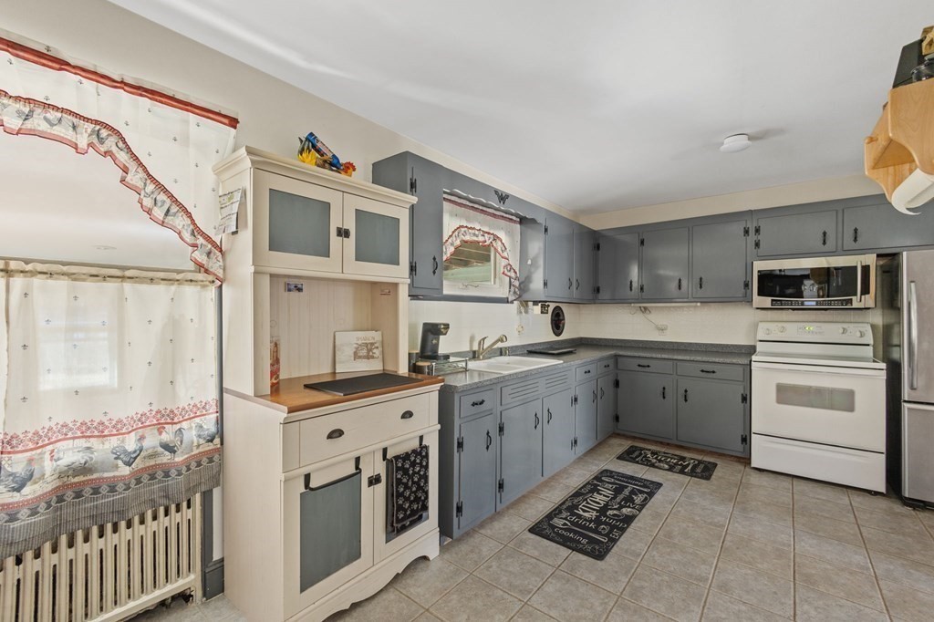1247 Bay Road Sharon, MA 02067 - Photo 13 of 41 a kitchen that has a lot of cabinets in it and wooden floors