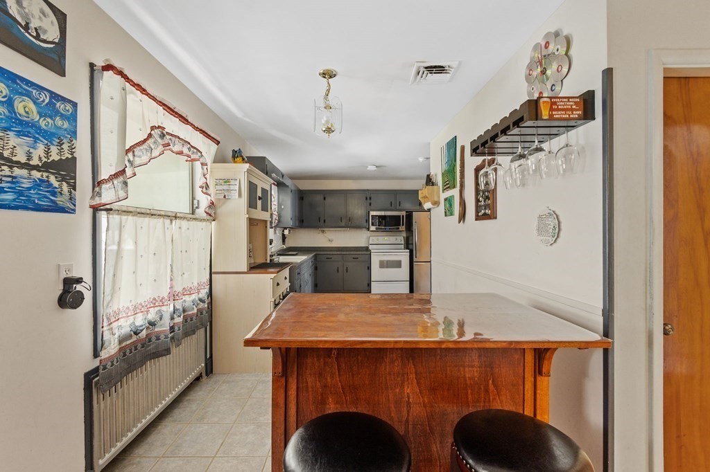 1247 Bay Road Sharon, MA 02067 - Photo 15 of 41 a view of kitchen island with furniture and stainless steel appliances