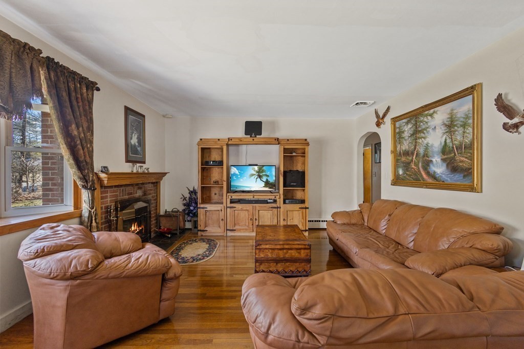 1247 Bay Road Sharon, MA 02067 - Photo 9 of 41 a living room with furniture a fireplace and a flat screen tv