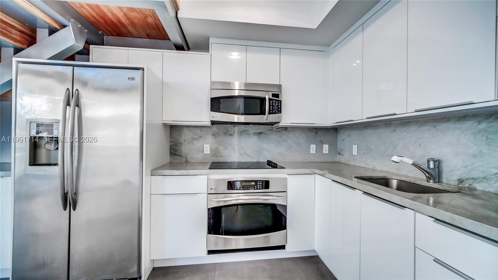 90 Southwest 3rd Street, Unit TH706 Miami, FL 33130 - Photo 11 of 37 a kitchen with stainless steel appliances granite countertop a stove a microwave and a refrigerator