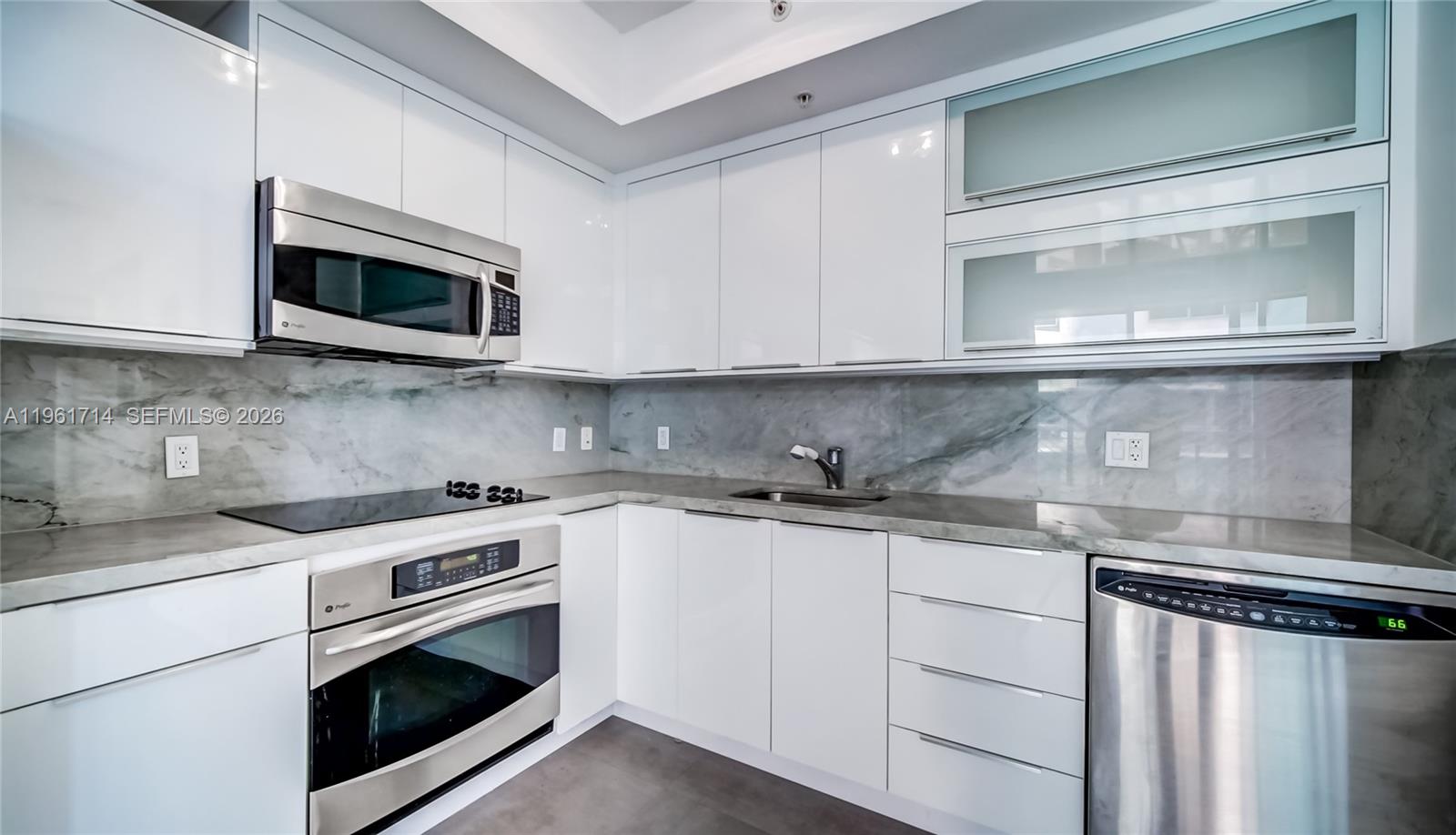 90 Southwest 3rd Street, Unit TH706 Miami, FL 33130 - Photo 10 of 37 a kitchen with stainless steel appliances granite countertop white cabinets a sink and a stove