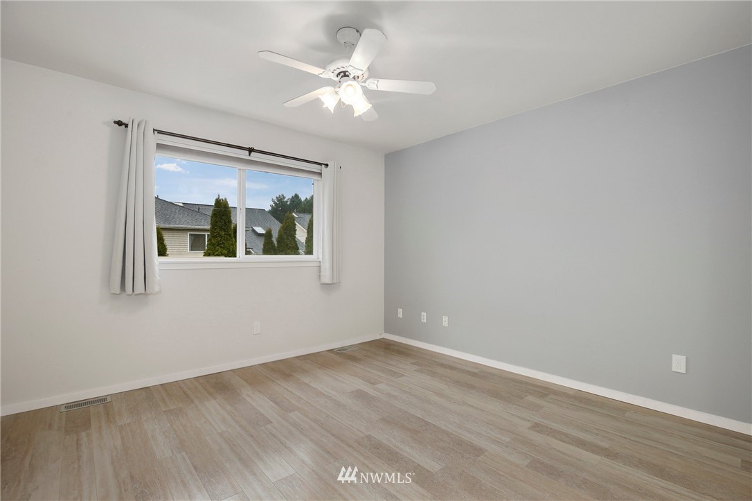17539 110 Lane Southeast, Unit 20 Renton, WA 98055 - Photo 11 of 25 a view of an empty room with wooden floor and a chandelier