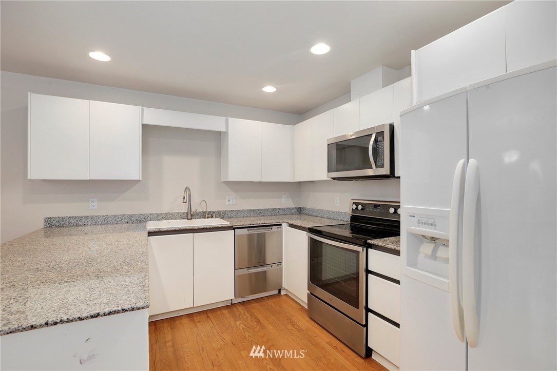 17539 110 Lane Southeast, Unit 20 Renton, WA 98055 - Photo 2 of 25 a kitchen with granite countertop cabinets stainless steel appliances and a counter space